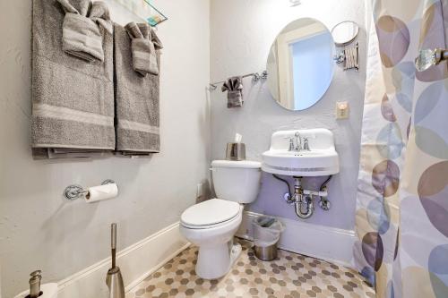 a bathroom with a toilet and a sink and a mirror at Historic Decatur Apt with City Square Views in Decatur