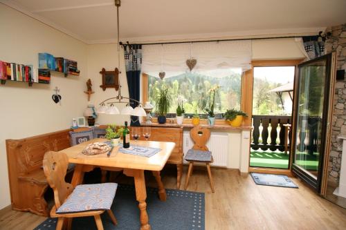a kitchen with a wooden table and chairs and a window at Alpenspatzl in Reit im Winkl