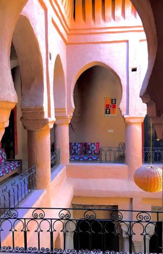 a building with two arches and a balcony at Riad La Perle Tamnougalte in Agdz
