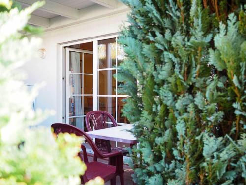 a table and chairs on a patio with a tree at FeWo "Stems - W5" in Prerow