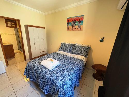 a bedroom with a bed with a blue and white blanket at Terra do Sol Pousada e Hostel in Porto Seguro
