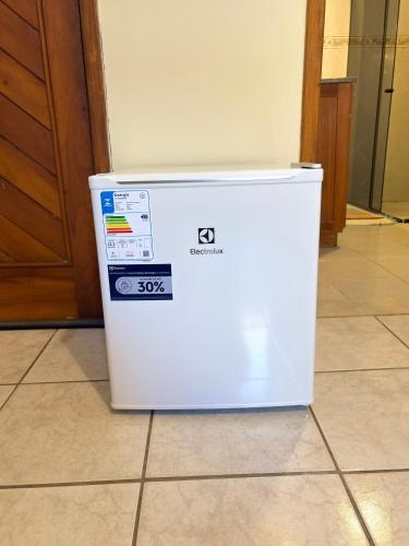 a white refrigerator sitting on the floor next to a door at Terra do Sol Pousada e Hostel in Porto Seguro
