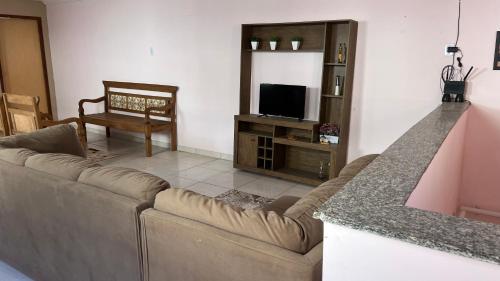 a living room with a couch and a television at Pousada Viver a Vida - No Centro Conservatória in Conservatória