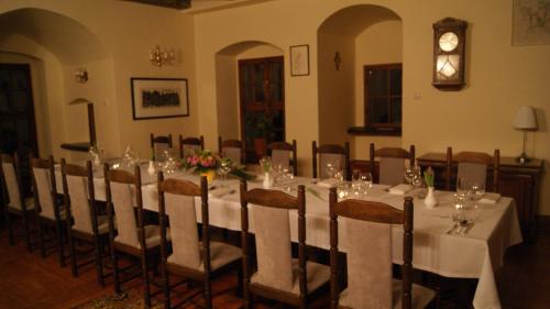 a room with a long table with chairs and wine glasses at Zamek na wodzie w Wojnowicach in Wojnowice