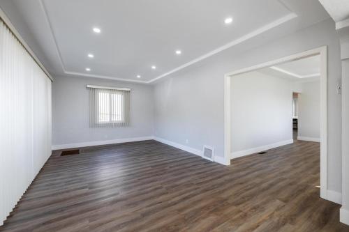 an empty living room with white walls and wood floors at Affordable Dorm Hayward in Hayward