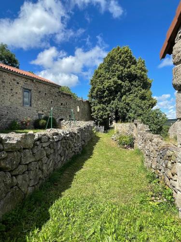 un vieux mur en pierre à côté d'un bâtiment dans l'établissement L'Establou d'Aboulin, à Saint-Christophe-dʼAllier