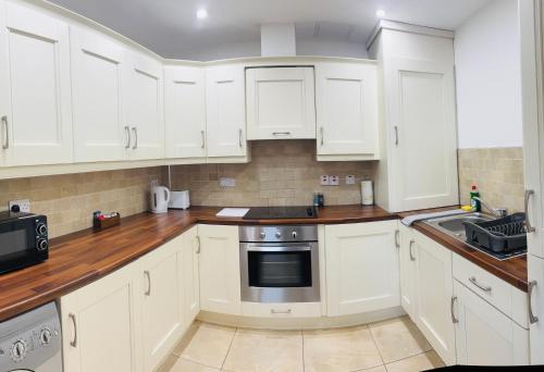 a white kitchen with white cabinets and a sink at Letterkenny Wild Atlantic Apartments in Letterkenny