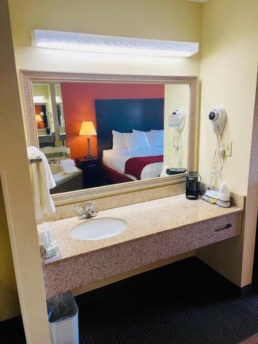 a bathroom with a sink and a large mirror at Baymont by Wyndham Indianapolis in Indianapolis