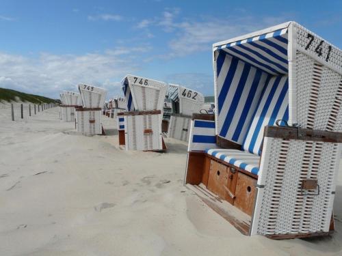 a row of beach chairs sitting in the sand at Exclusive Rollstuhlgerechte Wohnung " Ebbe " barreirefrei 3 Erw Klenkind in Ostfriesland in Utarp