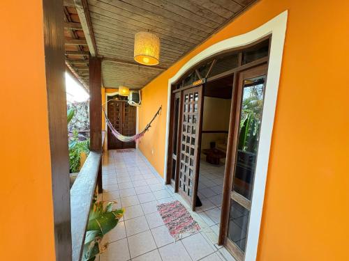 an orange house with a porch and a walkway at Terra do Sol Pousada e Hostel in Porto Seguro