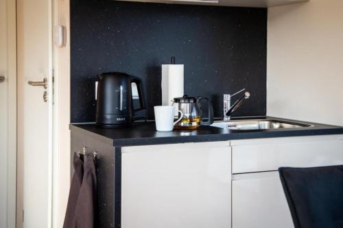 a kitchen counter with a sink and a coffee maker at Hausboot Bahama Mama in Klitten