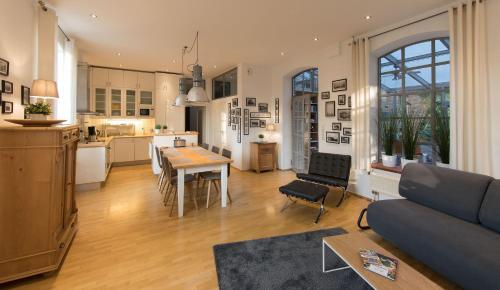 a kitchen and a living room with a couch and a table at LokoMotel-Wohnung, Luxus Ferienwohnung im Lokschuppen in Stadtlohn