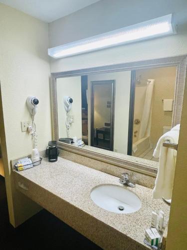 a bathroom with a sink and a large mirror at Baymont by Wyndham Indianapolis in Indianapolis