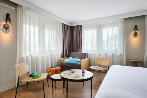 a room with a bed and a chair and a table at Moxy Annecy in Annecy