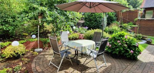 a table and chairs with an umbrella in a garden at Ferienhaus Korn in Bruchweiler-Bärenbach