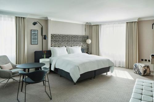 a bedroom with a bed and a table and a chair at London Marriott Maida Vale in London