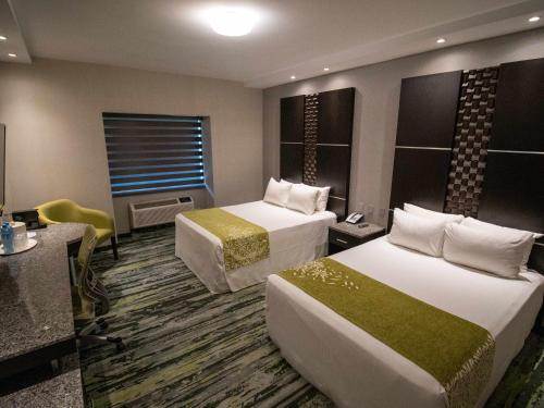 a hotel room with two beds and a desk at Hotel Araiza San Luis R.C. in San Luis Río Colorado