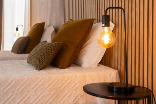 a bed with pillows and a table with a lamp at Central Guest House in Ponta Delgada