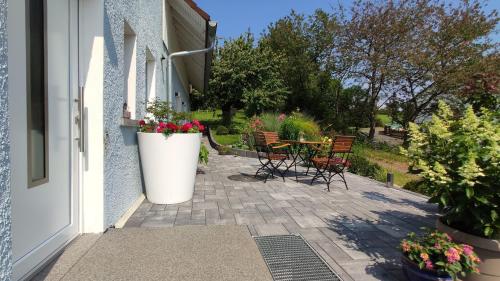 a patio with a table and chairs and flowers at Ferienwohnung Naumann in Schotten