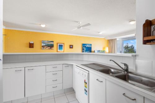a kitchen with white cabinets and a sink at 6- 'Cote D'Azur' 6 Douglas Street Sunshine Beach in Sunshine Beach