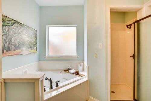 a bathroom with a bath tub and a window at Waterfront Home 30 Mi to New Orleans with Boat Dock in Slidell