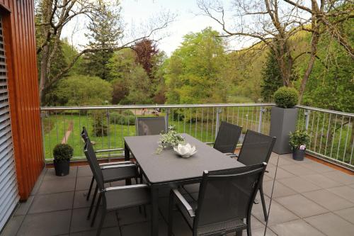 a patio with a table and chairs on a balcony at Villa Grün, Loft- Wohnung 09 in Tabarz
