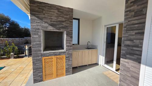 a kitchen with a large tv on a brick wall at Residence Giardino in Ugljan
