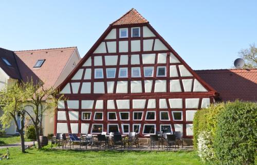 a half timberedbered house with tables and chairs at Libelle in Colmberg