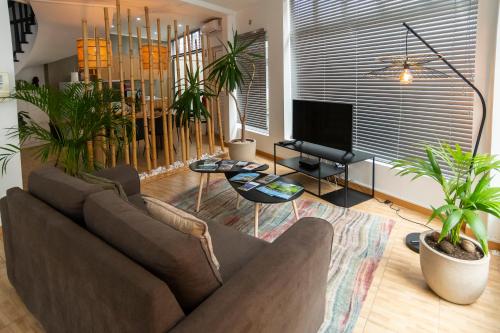 a living room with a couch and potted plants at Central Guest House in Ponta Delgada