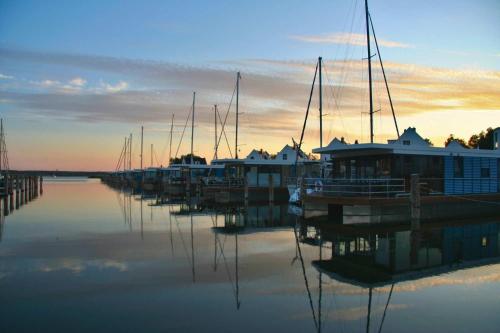 een groep boten aangemeerd in een jachthaven bij zonsondergang bij Hausboot Marama - LP10 in Peenemünde
