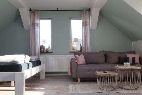 a living room with a couch and a bed at BLUMENSTIL Ferienwohnungen 2 in Bad Salzungen