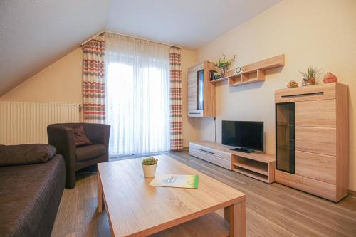 een woonkamer met een bank en een tafel bij Familienhof Brüning - Stadtblick in Meppen