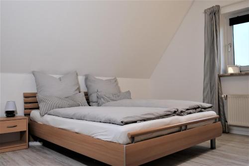 a bedroom with a bed with white sheets and pillows at FEWO Ostseeland in Grömitz