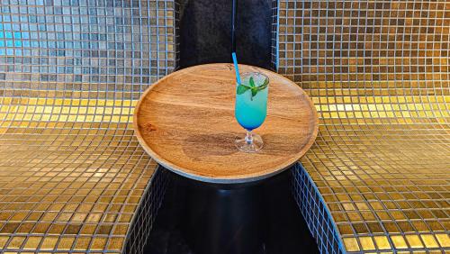 a blue drink sitting on a wooden table at Hotel Bucura in Călimăneşti