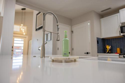 un bancone della cucina con una bottiglia verde accanto a un lavandino di Stylish Escape 3BDRM with fireplace a El Paso