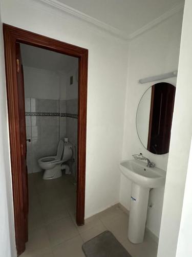 a bathroom with a toilet and a sink and a mirror at Résidence el fassi in Fès