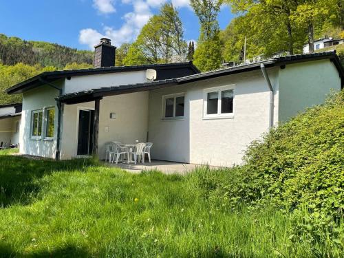 a small white house with a table and chairs at Landhaus am See 934 in Biersdorf