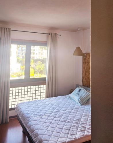 a bedroom with a bed and a large window at Apartment in Vilamoura with pool in Quarteira