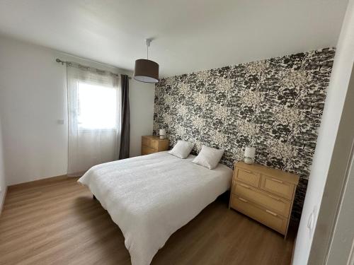 - une chambre avec un lit blanc et un mur noir et blanc dans l'établissement Les Lavandières, à Barbeville