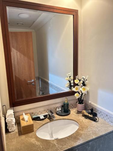 ein Badezimmer mit Waschbecken und großem Spiegel in der Unterkunft Adaz Home in Dubai