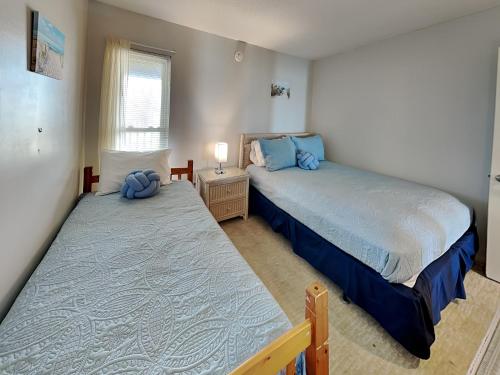 a bedroom with two twin beds and a window at A Wave From It All in North Topsail Beach
