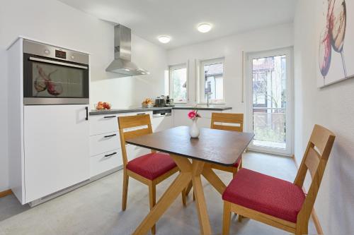 une cuisine avec une table, des chaises et un réfrigérateur dans l'établissement Thermen Appartement Gabriela, 52 qm, à Bad Krozingen