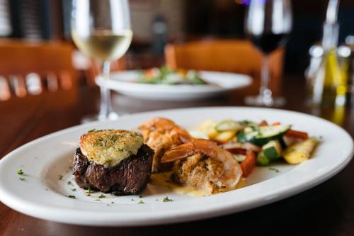 a plate with a steak and vegetables on a table at Crowne Plaza Shenandoah - The Woodlands Area by IHG in The Woodlands