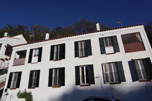 a white building with black windows on a street at Casas La Buganvilla Aracena in Aracena