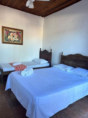 two beds in a room with blue sheets at La Mar Paraty Hospedaria 03 in Paraty