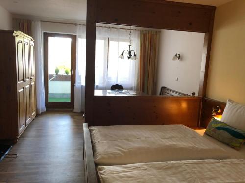 een slaapkamer met een bed en een groot raam bij FeWo-POR24 Pfronten in Pfronten