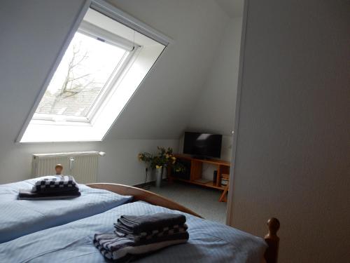 a attic bedroom with two beds and a window at Eichenpark 34 in Prerow