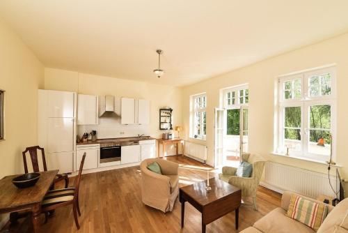 un soggiorno con un tavolo e una cucina di Ferienwohnung 7 mit Wasserblick, Balkon 2 Pers a Neuenkirchen