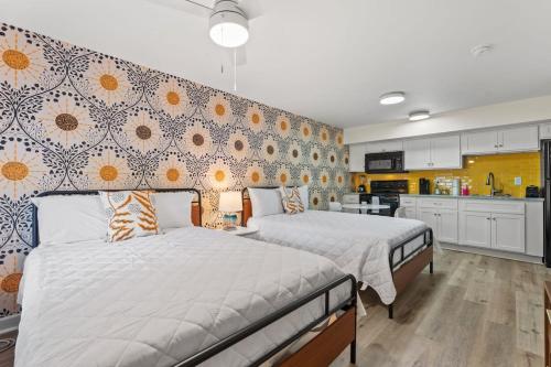 two beds in a large room with a kitchen at TreeHouse Lodge Walk to Beach Pet-Friendly 103 in Myrtle Beach