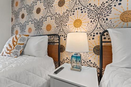 a bedroom with two beds and a lamp on a night stand at TreeHouse Lodge Walk to Beach Pet-Friendly 103 in Myrtle Beach